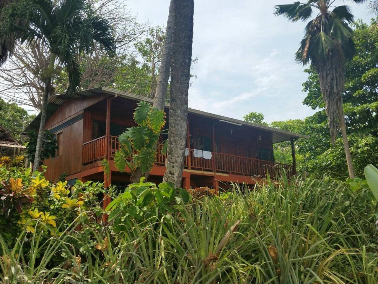 Wooden cabin with a balcony among the garden and trees